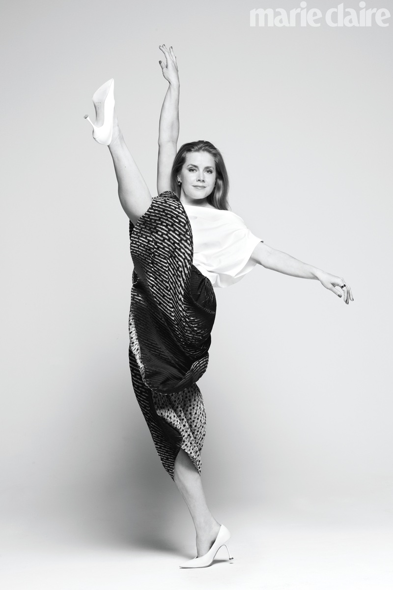 Kicking up her heels, Amy Adams poses in Issey Miyake top and pants with Manolo Blahnik shoes
