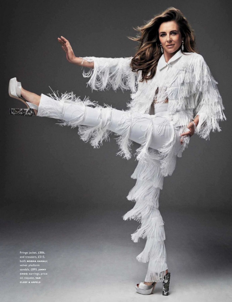 Kicking up her heels, Elizabeth Hurley wears Norma Kamali fringe jacket and pants with Jimmy Choo platforms