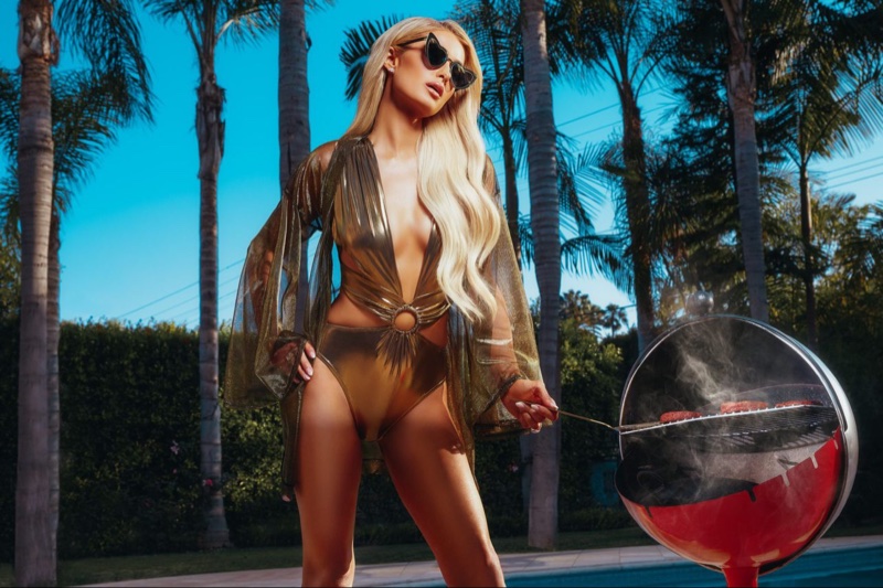 Wearing a gold swimsuit, Paris Hilton models Boohoo collaboration