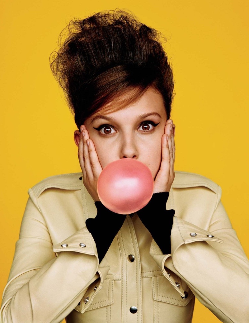 Posing with bubblegum, Millie Bobby Brown wears Calvin Klein dress and turtleneck