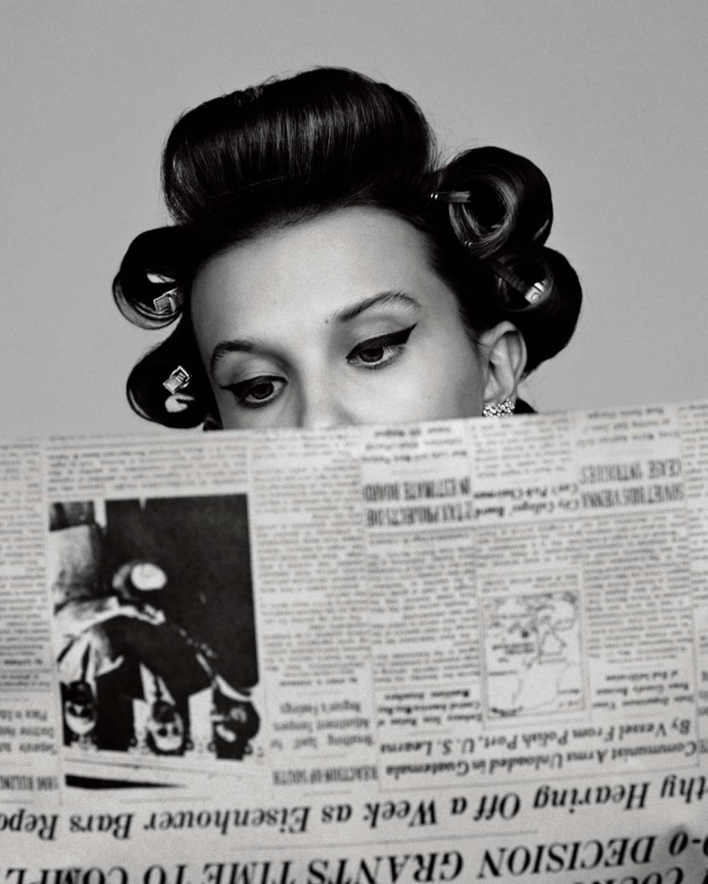 Reading a newspaper, Millie Bobby Brown wears Messika Paris earrings