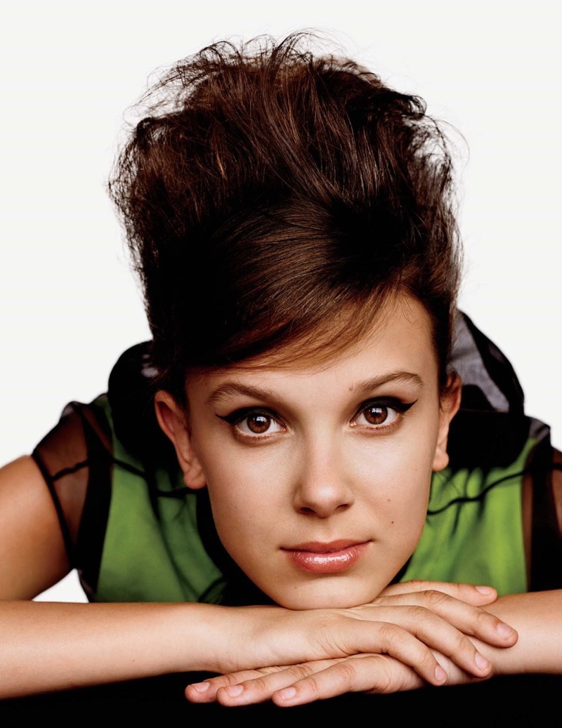 Wearing a beehive hairstyle, Millie Bobby Brown poses in Prada look