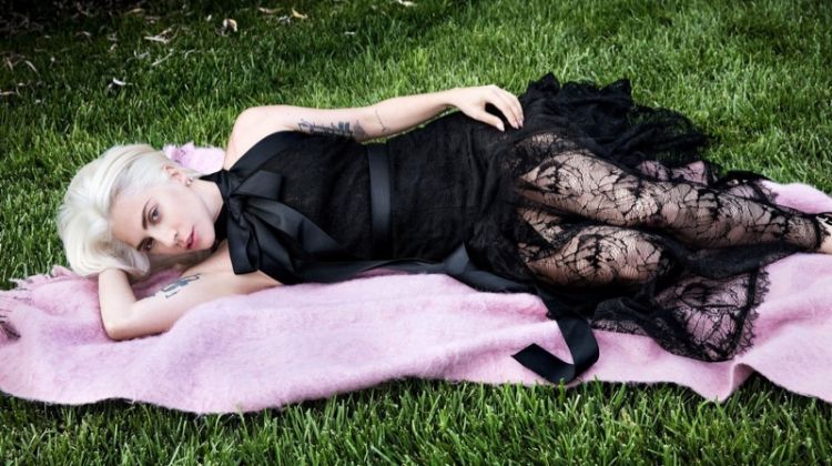 Laying in grass, Lady Gaga wears Chanel dress and Delfina Delettrez earring