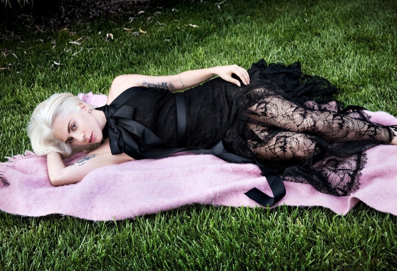 Laying in grass, Lady Gaga wears Chanel dress and Delfina Delettrez earring