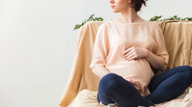 3 Causes for a False Pregnancy Test Pregnant Woman in Pink Top
