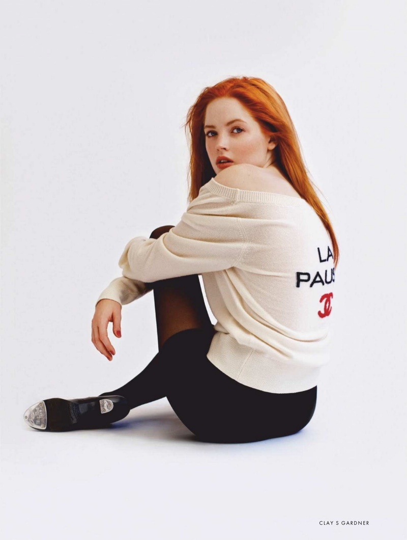 Actress Ellie Bamber wears Chanel sweater and earrings with Capezio tights and shorts