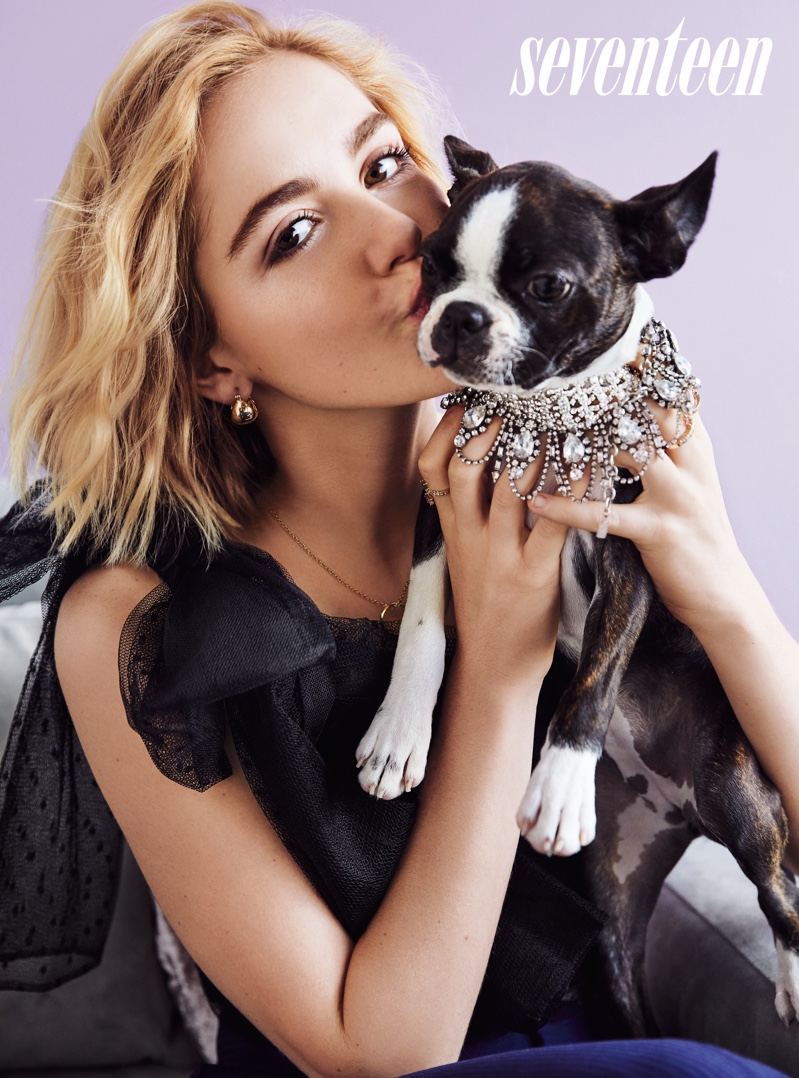 Posing with a puppy, Kiernan Shipka wears REDValentino top and Ana Luisa earrings