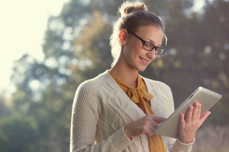 Woman Wearing Glasses and Sweater with Tablet