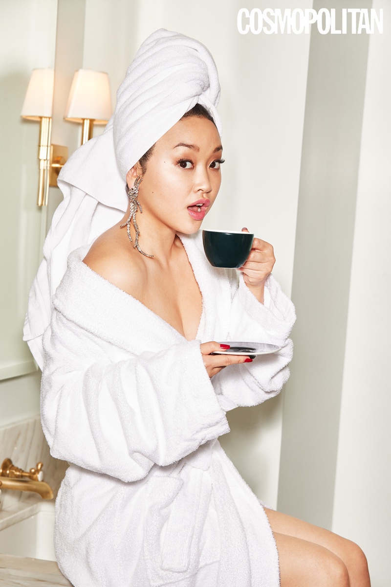 Wearing a robe, Lana Condor takes a sip of tea