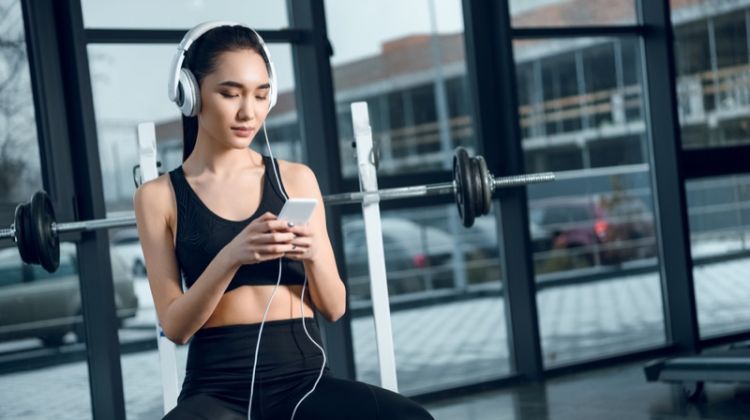 Do You Work Out with Your Phone? You Need These! Attractive Asian Model with Phone Working Out at Gym