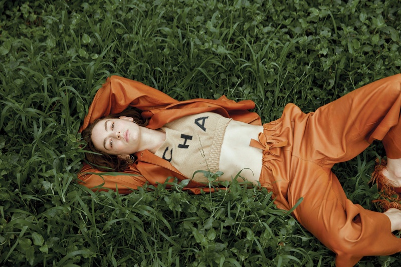 Surrounded by grass, Brigette Lundy-Paine wears a Chanel top with leather separates