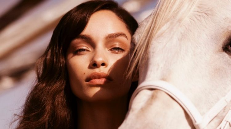 Model Luma Grothe poses with a white horse for Paco Rabanne promotional shot