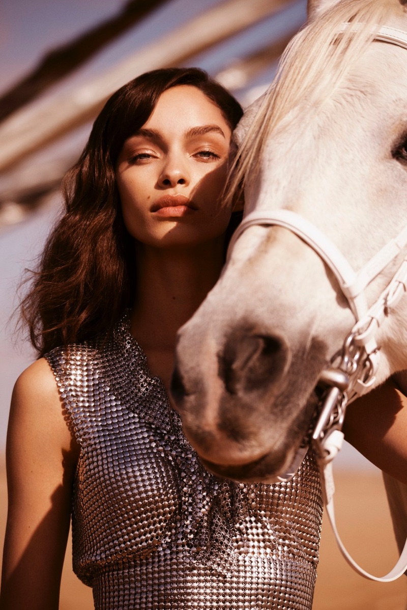 Model Luma Grothe poses with a white horse for Paco Rabanne promotional shot
