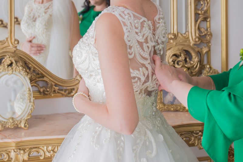 Bride Being Buttoned Into Wedding Dress