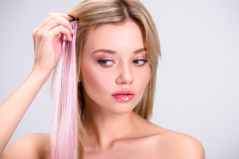 Model Applying Pink Hair Extensions