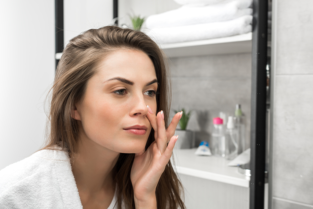Woman Checking Face in Mirror