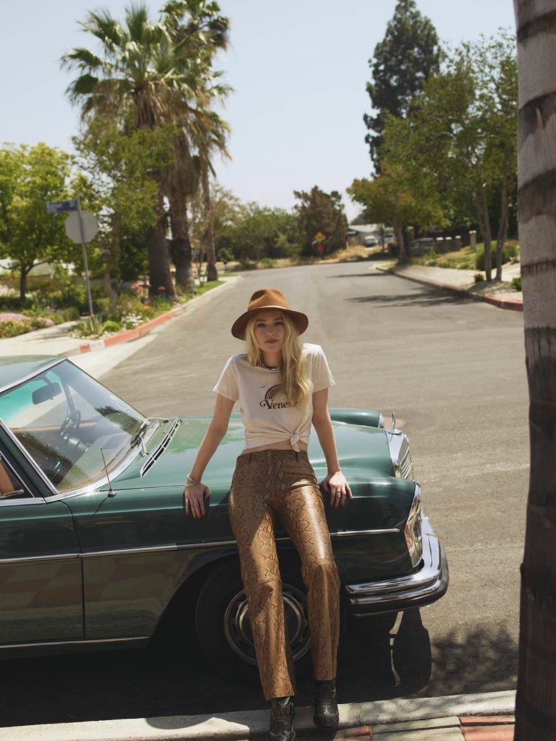 Posing outdoors, Dakota Fanning models Zimmermann t-shirt, Nili Lotan flared pants and Ganni boots