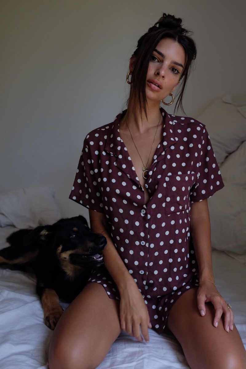 Modeling in bed, Emily Ratajkowski tries on Inamorata shirt in polka dot