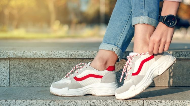 Ugly, Chunky Trainers are Here to Stay: Here’s Why Woman Adjusting Sneakers Watch