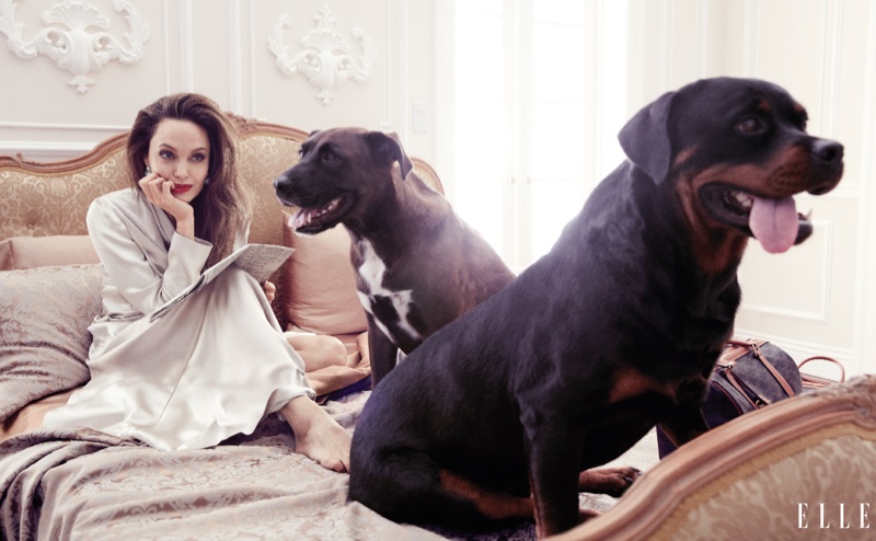 Laying in bed, Angelina Jolie models Galvan coat