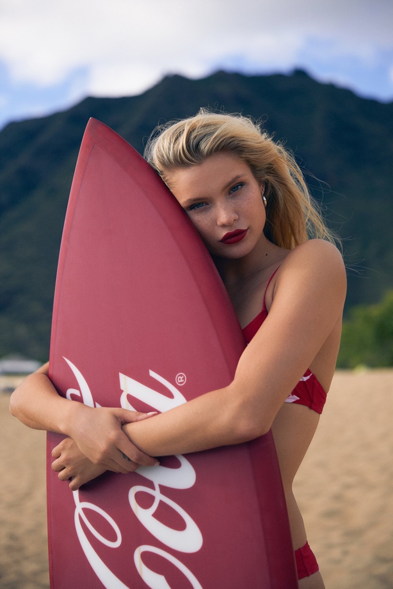 Posing with a surfboard, Josie Canseco fronts Kith x Coco-Cola campaign