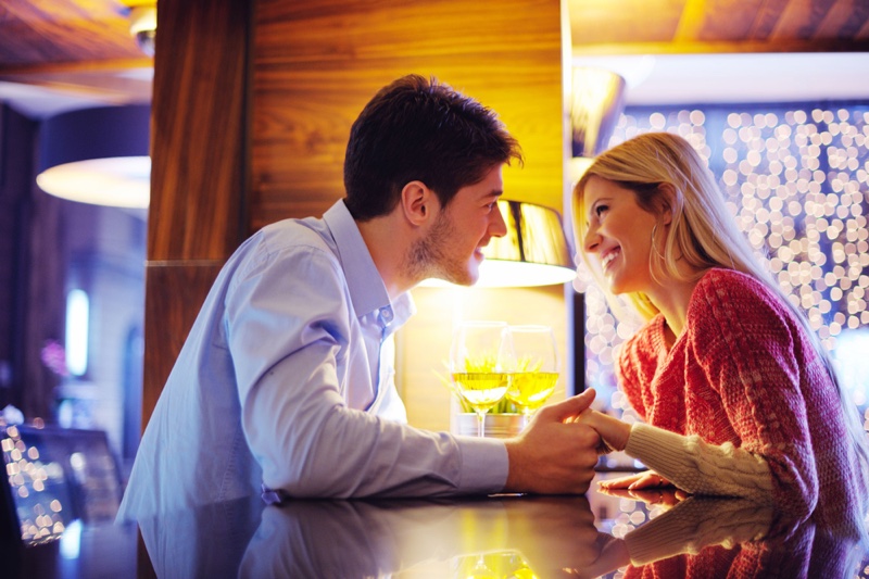 Attractive Couple Date Holding Hands Table