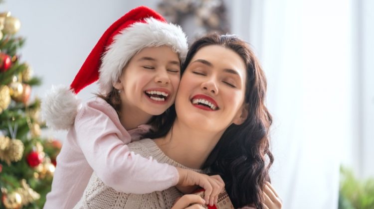 You Want to Exercise Etiquette When Sending Christmas Cards Mother Daughter smiling Christmas Santa Hat