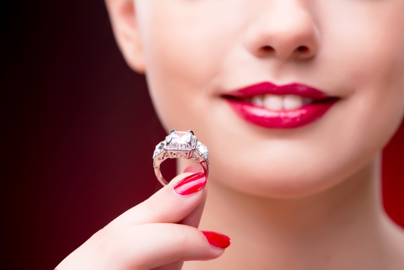 Closeup Model Holding Engagement Ring Red Nails