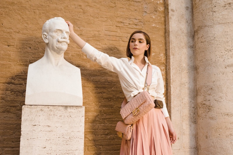 Kiernan Shipka poses in a statue for Fendi #BaguetteFriendsForever campaign