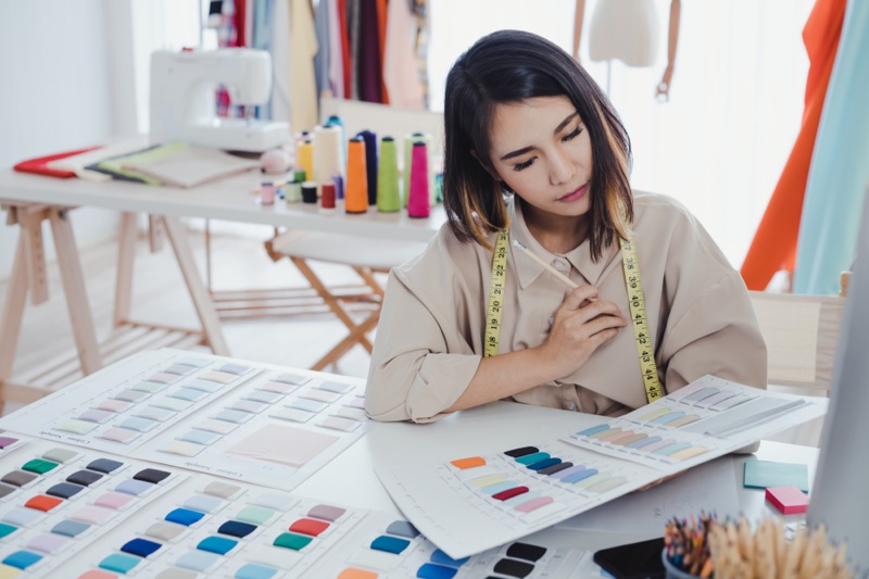 Asian Fashion Designer Looking at Fabric Swatches