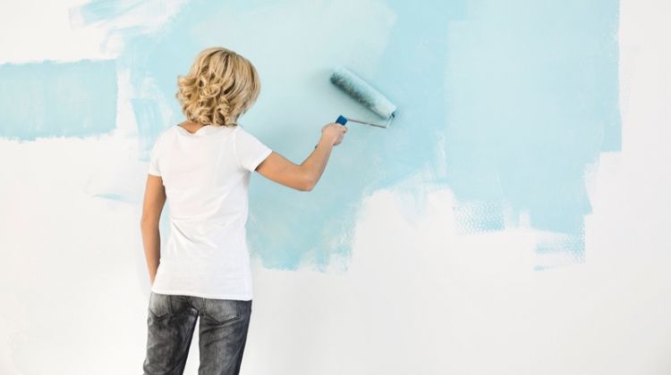 What Are the Latest Painting Trends? Blonde Woman Painting Wall Light Blue