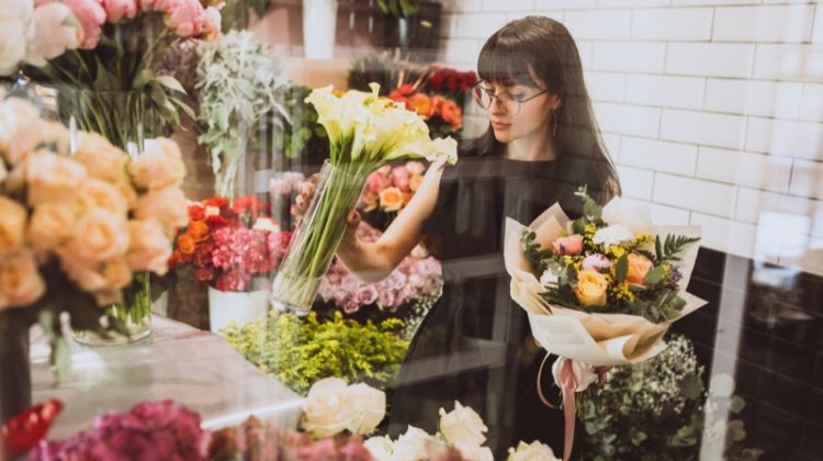 5 Tips on How To Start Flower Arranging Brunette Woman Holding Flowers Glass