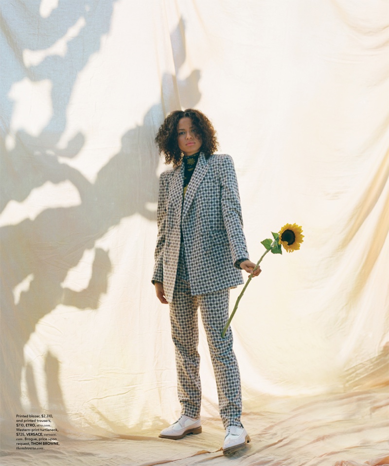 Suiting up, Gugu Mbatha-Raw poses in Etro blazer and trousers with Versace turtleneck and Thom Browne brogue