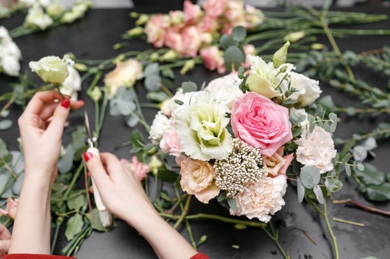 Woman's Hands Arranging Flowers Red Nails