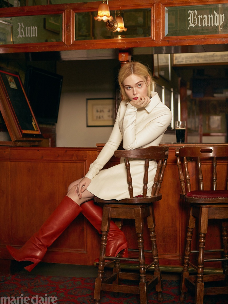 Posing at a bar, Elle Fanning wears Longchamp dress and Salvatore Ferragamo boots