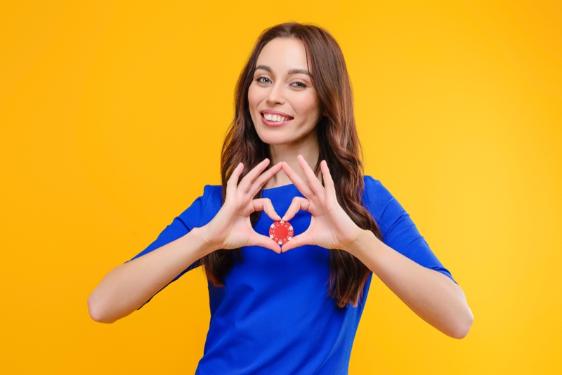 Smiling Brunette Holding Chip Gambling Blue Top