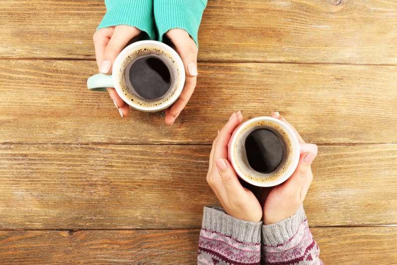 Female Hands Holding Coffee Cups