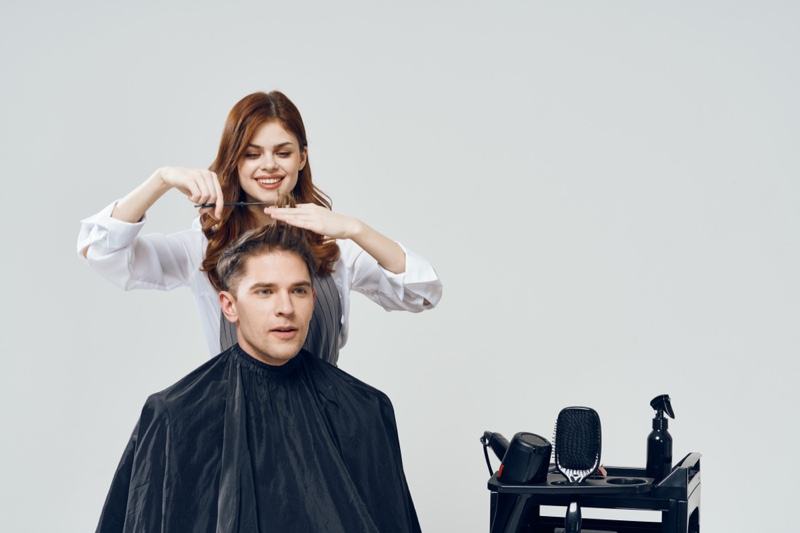 Female Model Cutting Male Model's Hair Salon Concept