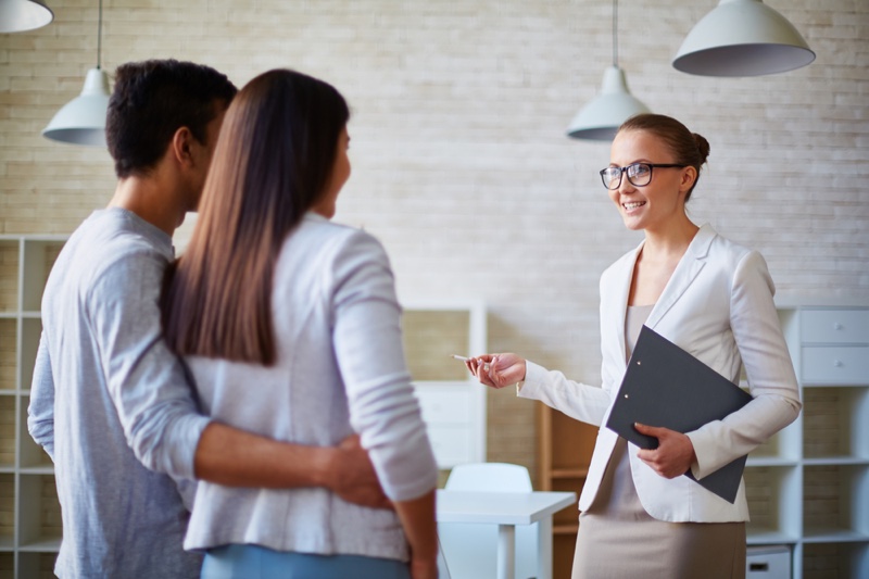 Female Realtor Showing Couple Home Professional Style