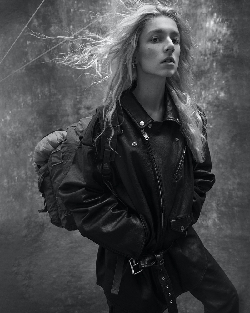 Hunter Schafer poses in Balenciaga jacket and pants with Galaxy Army Navy bag