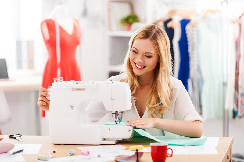 Smiling Blonde Woman Sewing Clothes