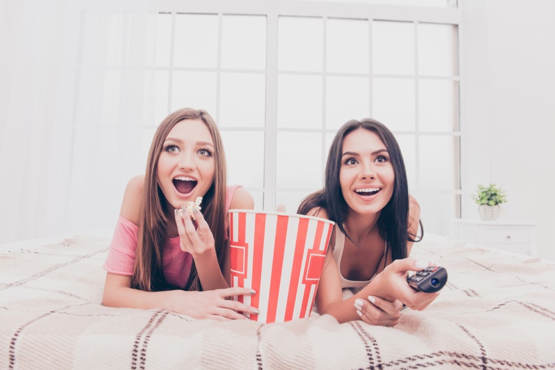 Two Girls Watching Movie Home Popcorn Bed