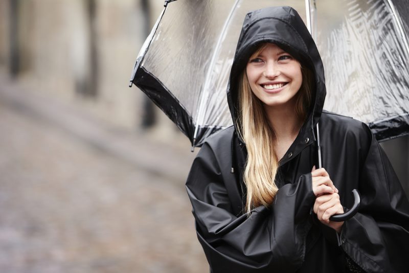Woman Smiling in Black Raincoat