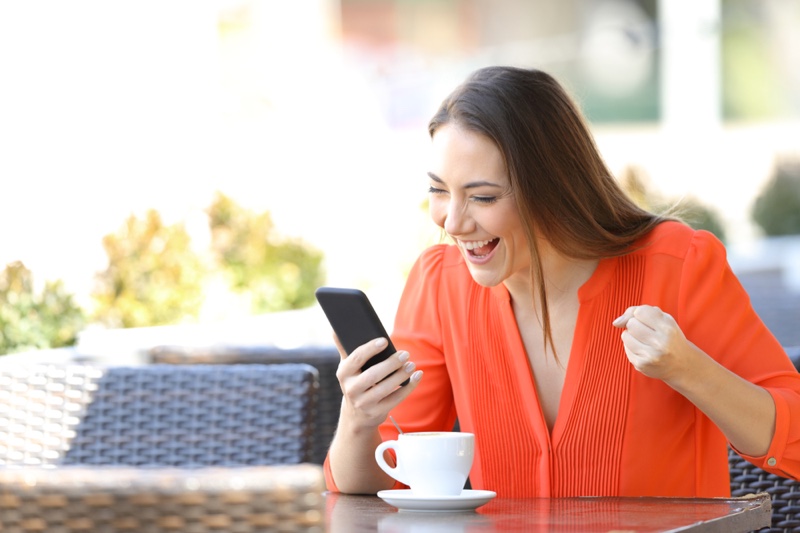 Excited Woman Checking Phone Cup Coffee