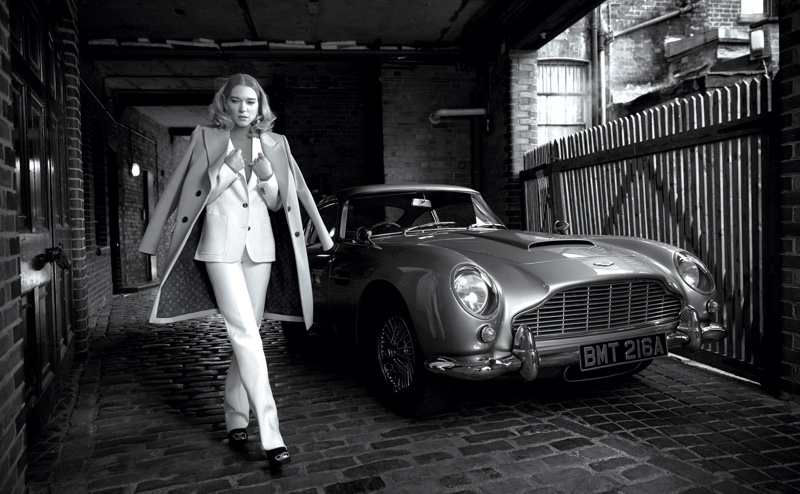 Suiting up, Lea Seydoux poses next to a vintage car in Louis Vuitton