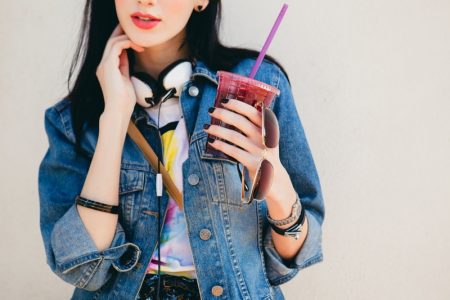 10 Best Ways To Wear A Denim Jacket Model Denim Jacket Holding Drink Sunglasses