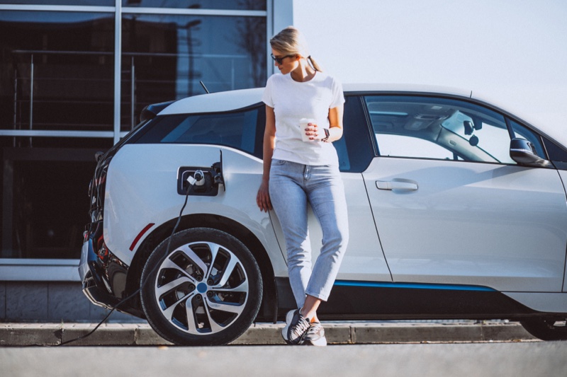 Stylish Woman Charging Electric Car