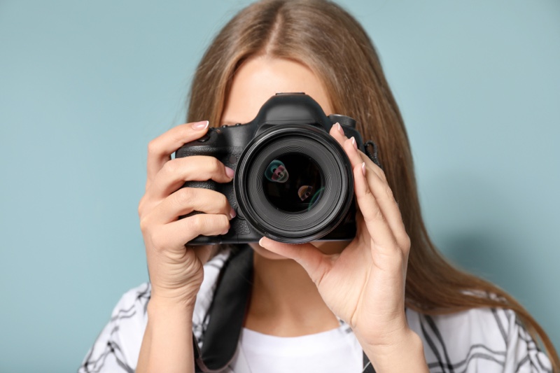 Woman Photographer Holding Camera Studio