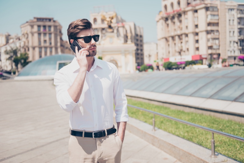 Man White Shirt Khaki Pants Sunglasses Phone Outside