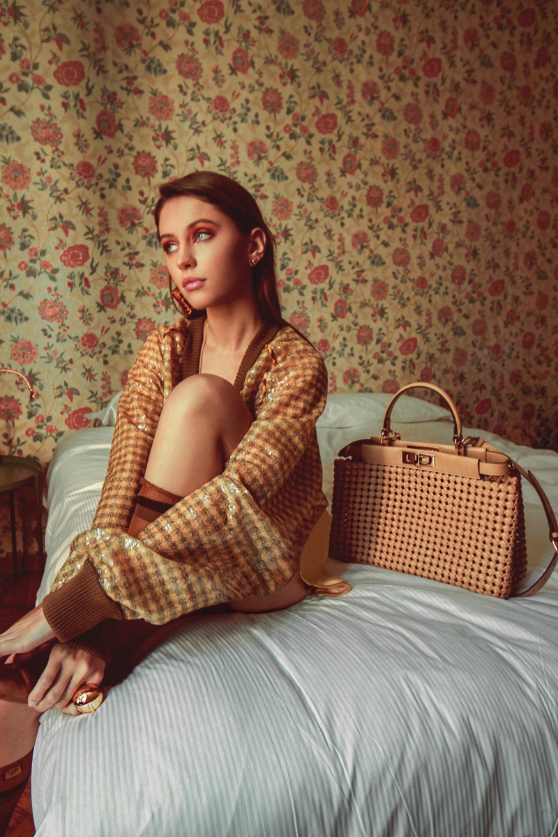 Posing in bed, Iris Law models alongside Peekaboo bag.